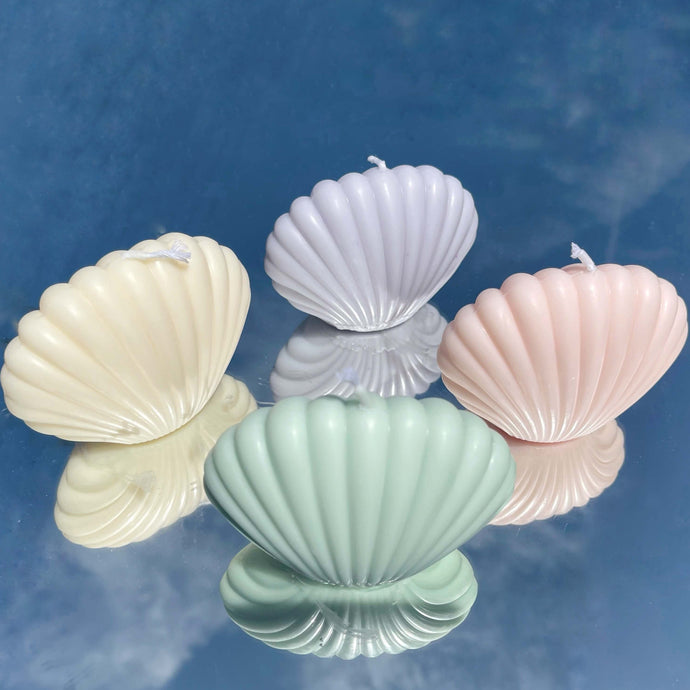 four shell candles in pink, ivory, blue, green